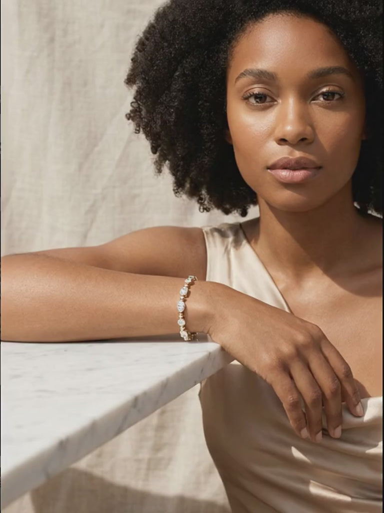 rosemary-tennis-bracelet worn by model, her draped wrist shifts slightly so the tennis bracelet catches the light